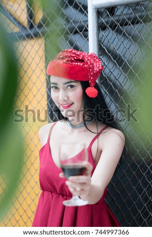 Young woman wear red shirt holding wine during party