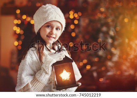 Beautiful little girl holding an old flashlight in the background blurred the Christmas tree.