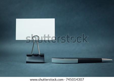 Business card with paper clip and pen.