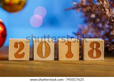 2018 blocks, creative greeting card on bokeh background. Blurred background. The stamp on the blocks. Happy new year of the Dog.