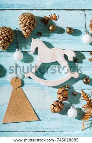 handmade paper angel and other Christmas ornaments on blue wood with shade