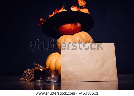 Small pumpkins put on each other and decorated with a black hat