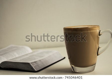 open bible and a cup of cappuccino with milk heart on white background Royalty-Free Stock Photo #745046401