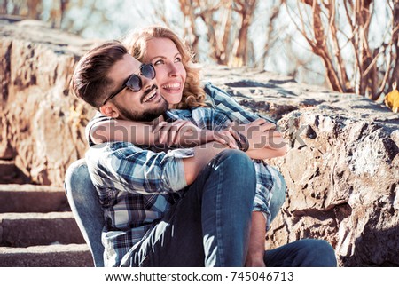 Beautiful young couple sitting on the stairs in a park.Love, romance, joy and happiness concept.