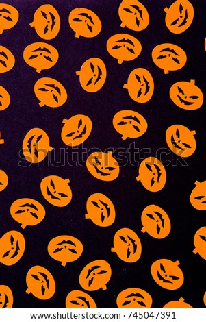 Hallowen still life concet, repetition of plastic miniature representing typical hallowen carachter like pumpkin, dead symbol and bat  over an orange background.