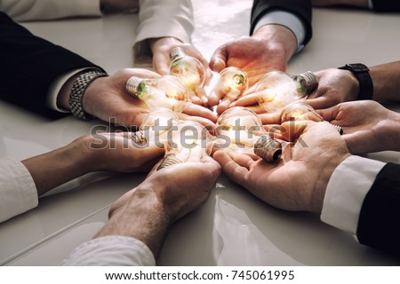 Teamwork and brainstorming concept with businessmen that share an idea with a lamp. Concept of startup Royalty-Free Stock Photo #745061995