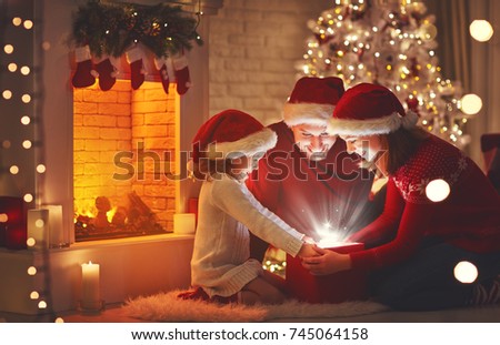 Merry Christmas! happy family mother father and child with magic gift near tree