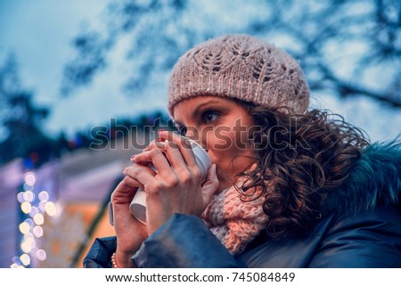 Woman Having Hot Drink Outdoors On Winter Market