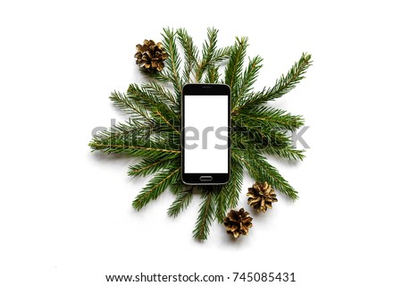 Christmas flatlay of fir branches and pine cones and smartphone with blank screen copy space for text, top view Royalty-Free Stock Photo #745085431
