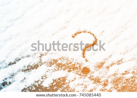 The question mark on snow-covered glass. Toned picture