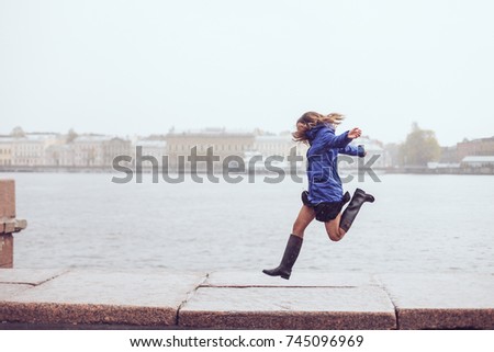 A girl is jumping near the river