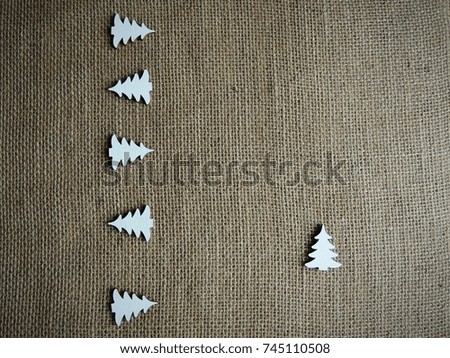 White wooden decoration trees on brown textured fabric burlap background.