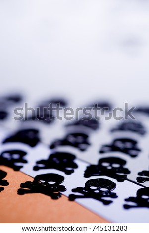 Hallowen still life concet,repetition of  miniature representing typical halloween and games carachter like death sign and beetle displayed in row aka space invaders style against an orange background