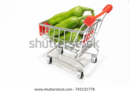 Green fresh peppers in a mini market cart