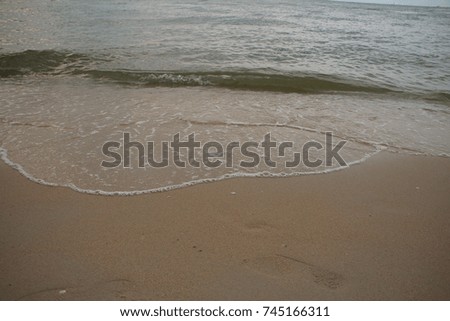 the calm waves hit the sandy beach