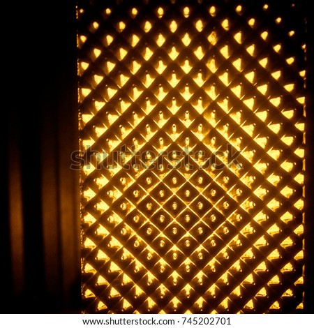 abstract blur soft light of ligh bulb behind glass pattern.Night photography film grain.have copy space for input your text or content