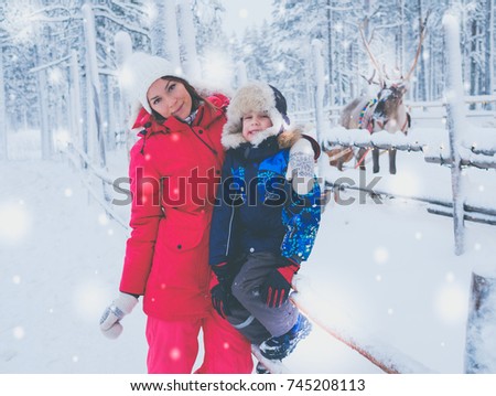 Happy mother with her son in a snow