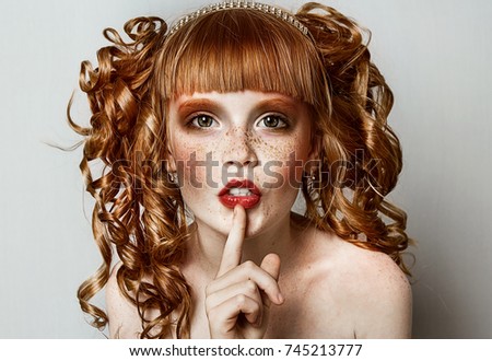 Beautiful red-haired freckled girl with curly hair