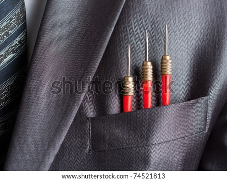 Business concept - three red darts in businessman suit pocket