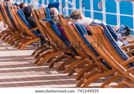 Sea Travel and Cruise Ship Relax. People Relaxing on Deckchairs During Transatlantic Cruise. Royalty-Free Stock Photo #745249039