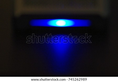 Small server with blue light glowing in dark room. Calgary, Alberta, Canada.