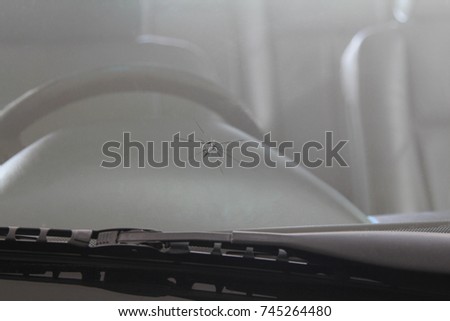 Damaged car front windshield with cracks caused by splashing debris. Royalty-Free Stock Photo #745264480