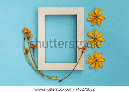 Wooden picture frame decorate with yellow flower on blue background