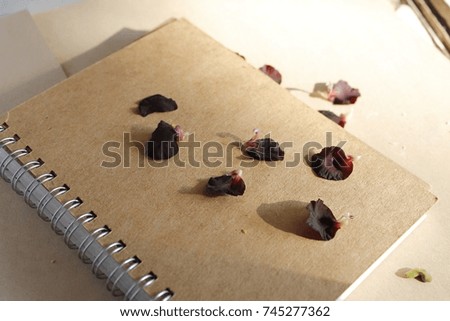 Black flower petals on brown notebook