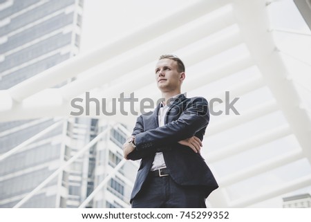 Portrait of happy businessman standing on front of business center.