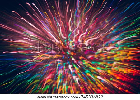 Abstract background of colorful lines in motion on black. Bokeh of defocused curves, blurred rainbow neon leds, festive backdrop of holidays and celebrations, fireworks and salute