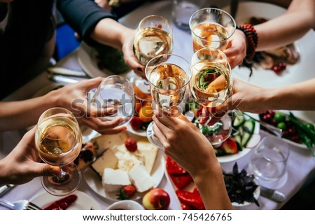 Glasses of white wine seen during a friendly party of a celebration. Royalty-Free Stock Photo #745426765