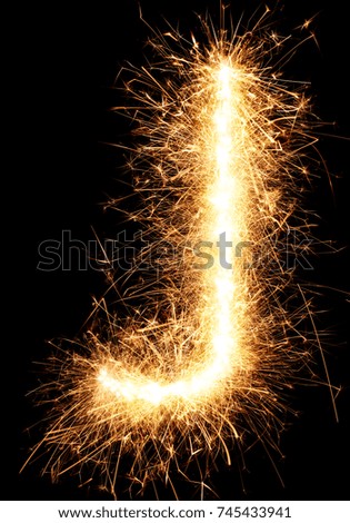 Sparkler firework light alphabet J isolated on black background