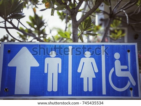 Outdoor public toilet sign under the tree