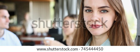 Beautiful smiling cheerful girl at cafe look in camera with colleagues group in background. White collar worker at workspace job offer modern lifestyle client visit profession train concept