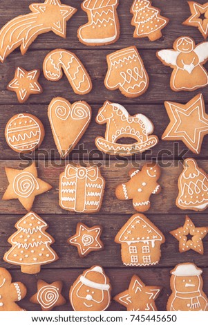 Top view of different shapes of nicely decorated Christmas cookies on wooden background