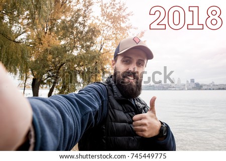 young guy with a beard waiting for the celebration of the new year, self portrait picture thumb up