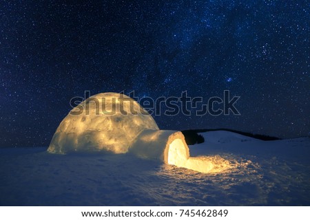 Fantastic winter landscape glowing by star light. Wintry scene with snowy igloo and milky way in night sky. Carpathian mountains. Santa house from snow,  ideal New Year and Christmas background 