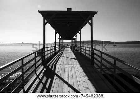 The perfect pier over the calm sea. Bright sky and wonderful nature.