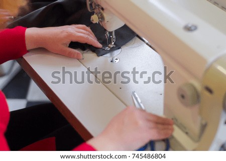 close up picture of seamstress using sewing machine 