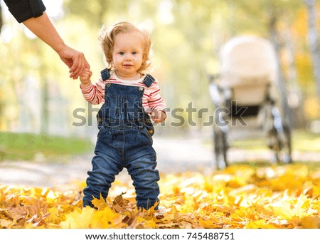  little daughter in an autumn park spend fun time