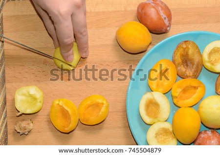 Hand cuts fruit on a wooden board