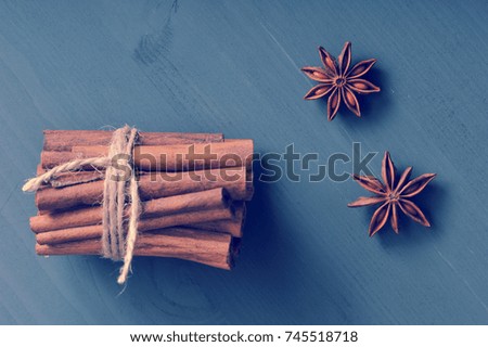 cinnamon sticks tied with a rope and the seeds of anise on dark rustic wooden background - top view