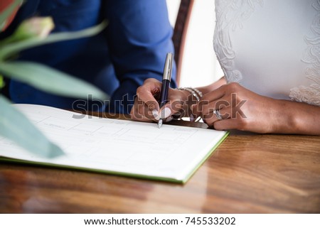 Bride signing marriage certificate wedding