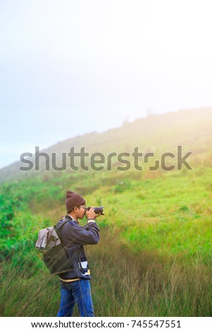 one man Backpack adventure Travel Up the Hill travel nature Green pasture jacket and Fur hat photographer Mountain