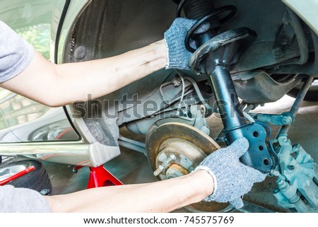 Changing car shock absorber at my home. Royalty-Free Stock Photo #745575769