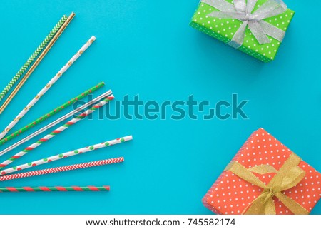 Christmas and New Year holiday composition with gift boxes, cocktail tubes on the blue background. Top view, flat lay. Copyspace
