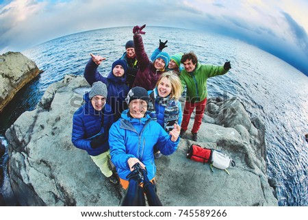 funny laughing friends near the sea in winter taking selfie together