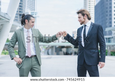 Profession two businessmen touching hands show commitment after received new project in cityscape background, business people concept 