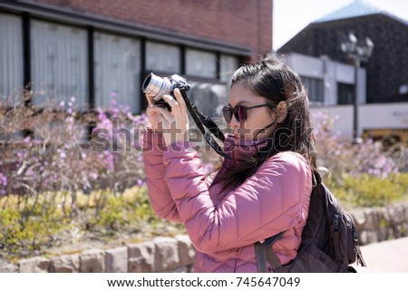 Young lady take a photography on her vacation in winter.