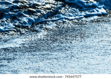 close up of the sea water affecting the sand on the beach, sea waves calmly flowing sand, relaxing view, summer time